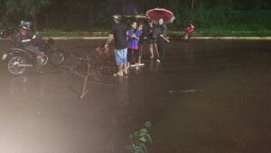 Fam&iacute;lia enfrenta chuva e alerta motoristas em via alagada de Campo Grande