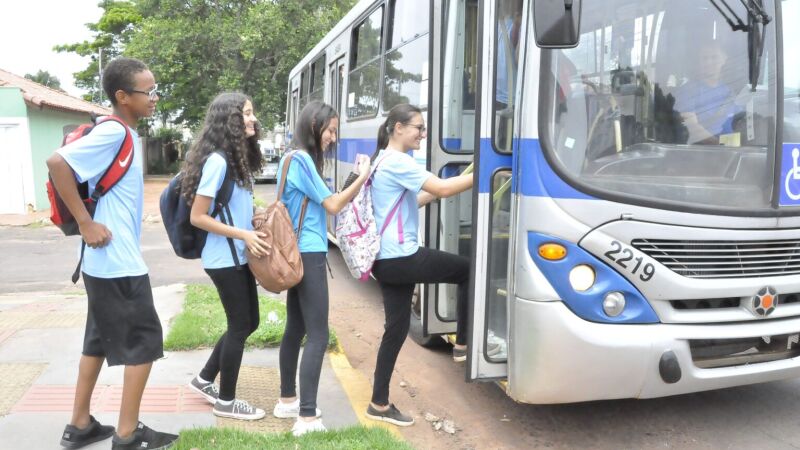 Alunos pegando ônibus para irem estudar