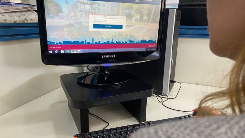 Pessoa consultando valor de IPTU de sua casa pela internet 