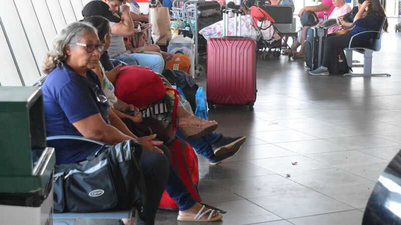 Pessoas de malas feitas e prontas para viajar na rodoviária