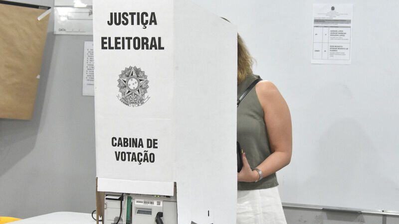 Pessoa votando na cabine eleitoral em 2024