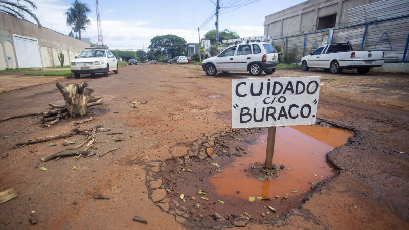 Placa alerta motoristas sobre buraco na via pública
