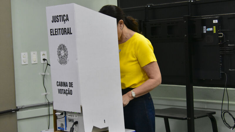 Mulher depositando seu voto na urna eletrônica