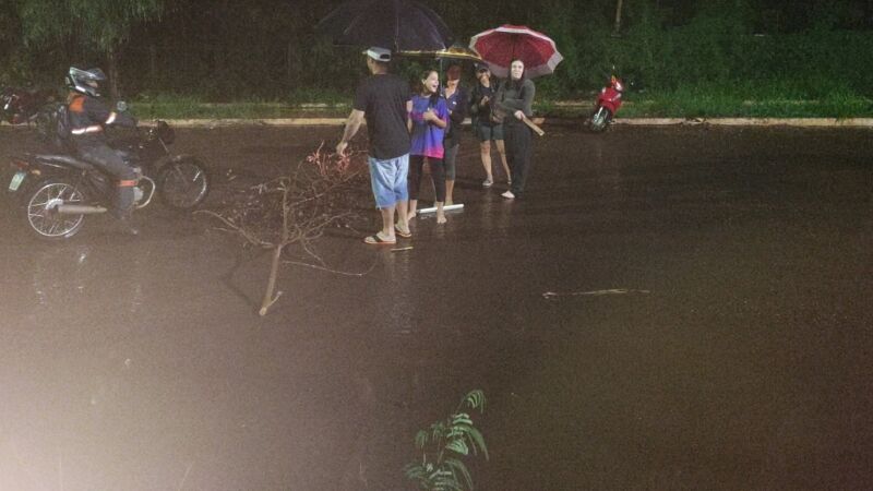 Moradores enfrentaram a chuva para sinalizar trecho alagado e alertar motoristas na Vila Popular, em Campo Grande, nesta quinta-feira (15).