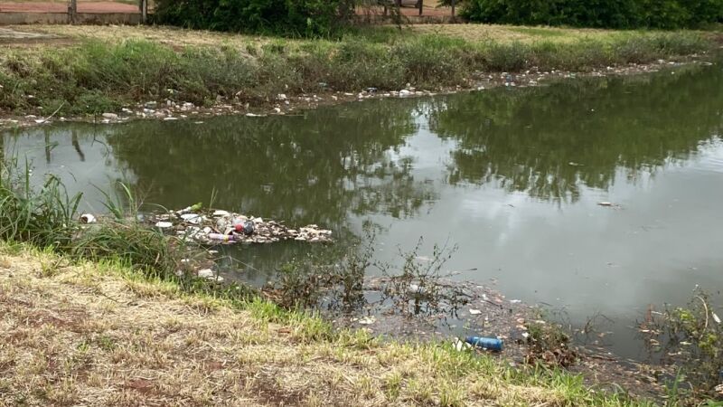 Lixo se acumula nas margens de piscinão que transbordou durante as chuvas em Três Lagoas.