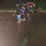 Fam&iacute;lia enfrenta chuva e alerta motoristas em via alagada de Campo Grande