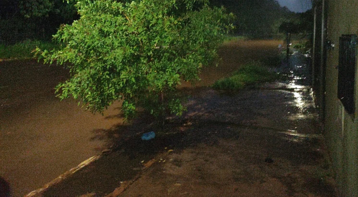 Moradores enfrentaram a chuva para sinalizar trecho alagado e alertar motoristas na Vila Popular, em Campo Grande, nesta quinta-feira (15).